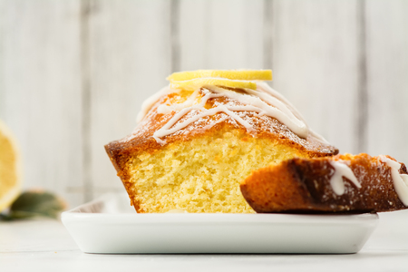 Lemon loaf cake with white glaze and lemon slices. Selective focus. Space for textの写真素材