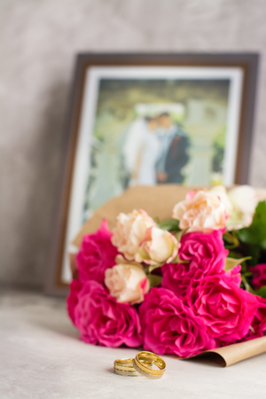 Wedding rings and roses bouquet. Valentines day card. shallow depth of field. Toned imageの写真素材