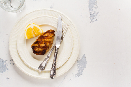 Grilled chicken breast on white plate. Top view. Space for textの写真素材