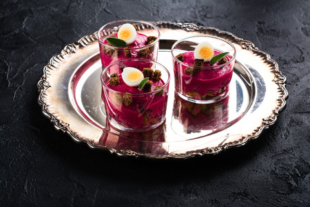 Traditional russian salad dressed herring with vegetables on festive backgroundの写真素材