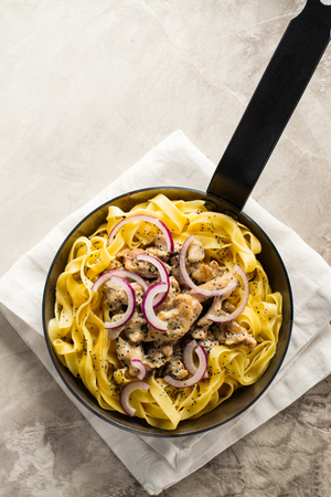 Tagliatelle pasta with chicken, cream sauce and poppy seeds. Space for textの写真素材