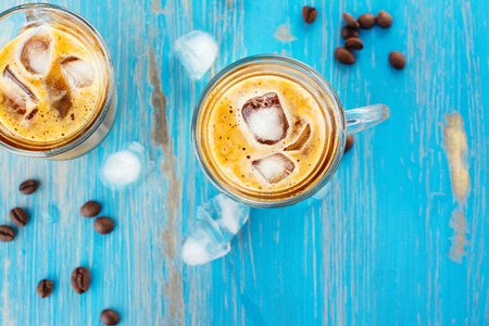 Refreshing iced coffee with cream over blue summer backgroundの写真素材