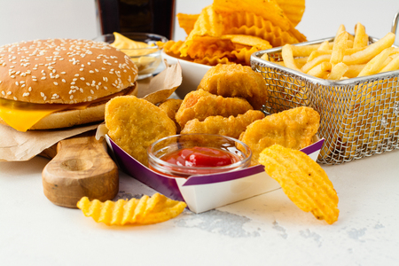 Junk food on white table. Fast carbohydrates not good for health, heart and skinの写真素材