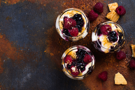 Homemade dessert in glass jars. Cheesecake, trifle, mouse on grunge stone background. Copy spaceの写真素材