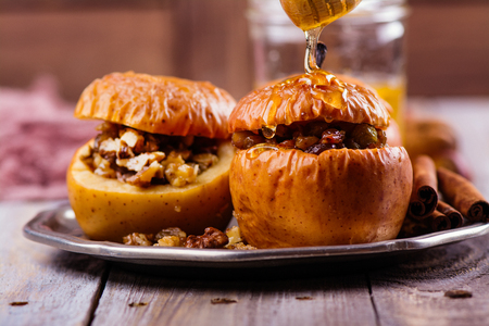 Baked apples stuffed with honey, raisin and nuts. Autumn dessert. Copy spaceの写真素材