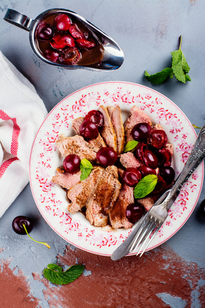 Cooked duck breast fillet with cherry sauce. Summer dinner concept. Space for textの写真素材