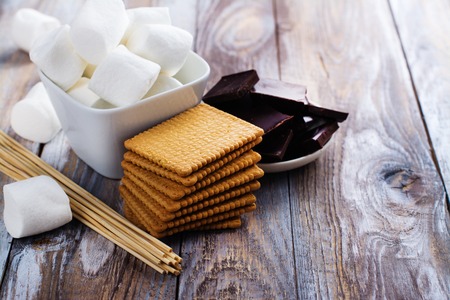Smores dessert ingredients on wooden table. Picnic or camp concept. Space for textの写真素材
