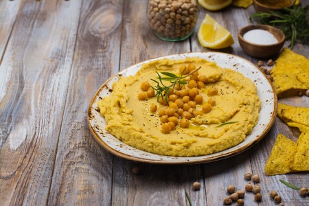 Traditional hummus and ingredients on wooden table. Copy spaceの写真素材