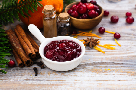 Cranberry sauce with ingredients on wooden table. Space for textの写真素材