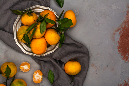 Tangerines with leaves on stone table. Copy spaceの写真素材