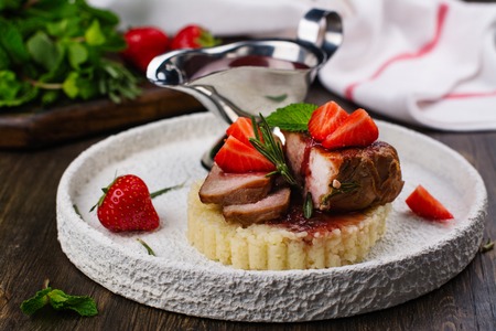 Grilled veal steak with couscous and strawberry sauce. Holidays dinner concept. Copy spaceの写真素材