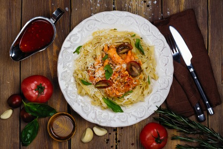 Homemade italian pasta with tomato sauce, chicken, and basilの写真素材