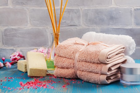 Spa composition with cotton towels, aroma oil, sea salt and stones on blue backgroundの写真素材