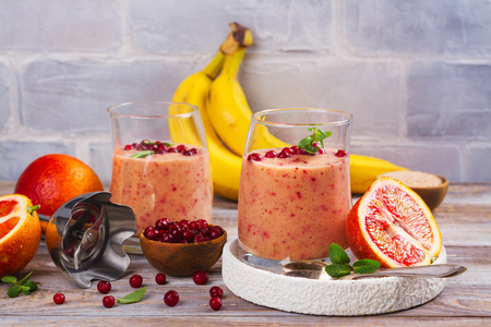 Healthy refreshing pink smoothie with , red oranges, cowberry and branの写真素材