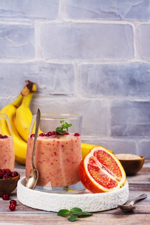 Healthy refreshing pink smoothie with , red oranges, cowberry and branの写真素材
