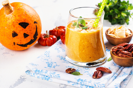 Pumpkin smoothie with coconut chips, pecan nuts, cinnamon and mintの写真素材