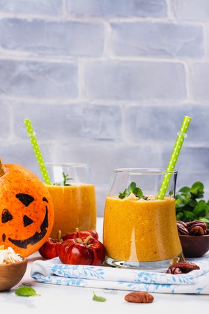 Pumpkin smoothie with coconut chips, pecan nuts, cinnamon and mintの写真素材