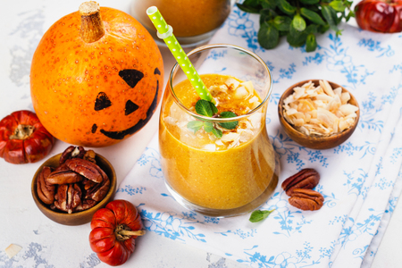Pumpkin smoothie with coconut chips, pecan nuts, cinnamon and mintの写真素材