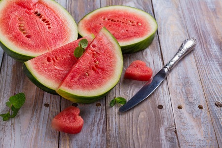 Fresh ripe watermelon slices and mint on wooden tableの写真素材