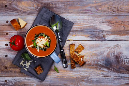 Tomato soup with pesto sauce and parmesan cheese in a ceramic cupの写真素材