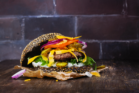 Homemade black burger with tzatziki sauce, shredded cheese and meat puttyの写真素材