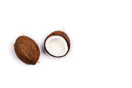 Coconut halves and leaves on white backgroundの写真素材