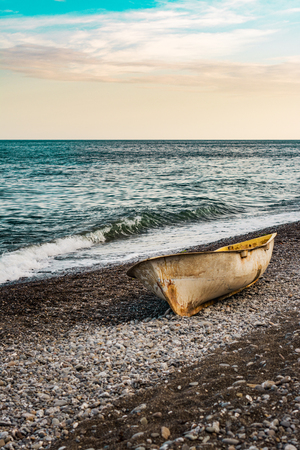 Lonely boat on the sunset beachの写真素材