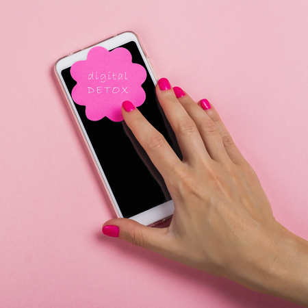Female hand reaching for cell phoneの写真素材
