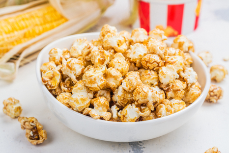 Caramel popcorn in a white bowlの写真素材