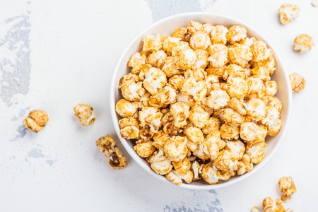 Caramel popcorn in a white bowlの写真素材