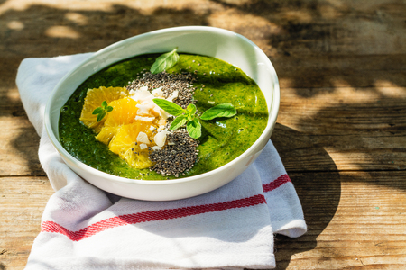 Green smoothie bowl with banana, spinach, chia seeds and orangesの写真素材