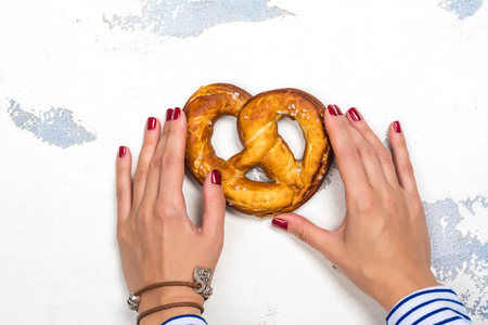 Bavarian pretzel in womans handsの写真素材