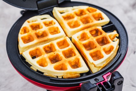Waffles in an iron waffle makerの写真素材