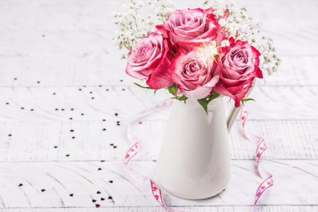 Pink roses in a white pitcherの写真素材
