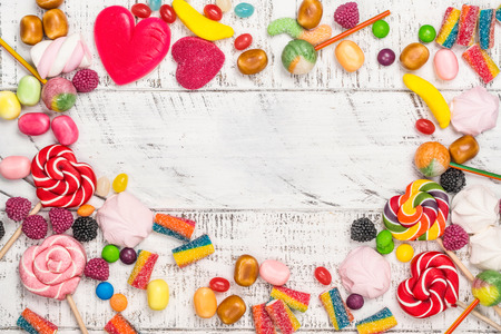 Candies, lollipops and jelly worms on tableの写真素材