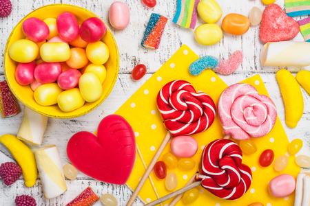 Candies, lollipops and jelly worms on tableの写真素材
