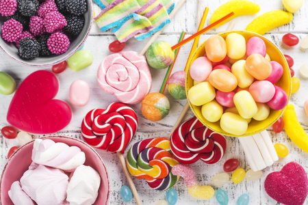 Candies, lollipops and jelly worms on tableの写真素材