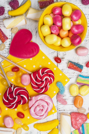 Candies, lollipops and jelly worms on tableの写真素材
