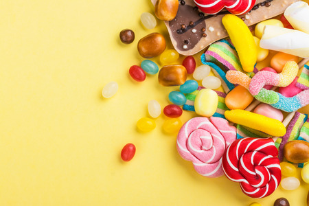 Candies, lollipops and jelly worms on tableの写真素材