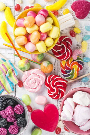 Candies, lollipops and jelly worms on tableの写真素材