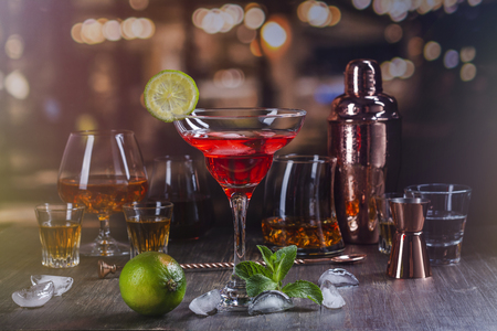 Martini or margarita cocktail drink. Assortment of different strong alcohol drinks on bar counter over night lights background. Copy spaceの写真素材