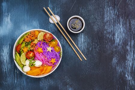 Rainbow noodle with vegetables. Unicorn buddha bowl with colorful pasta, fruits and vegetables. Healthy nutrition food. Copy spaceの写真素材