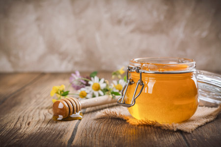 Glass jar with floral liquid honeyの写真素材