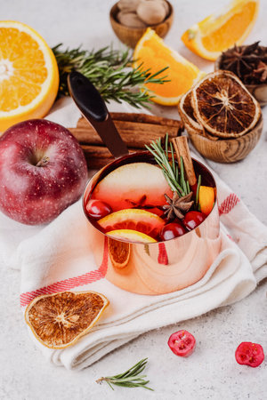 Hot mulled wine with fruits and spices in a copper potの写真素材