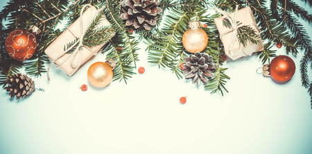 Christmas retro background. Spruce branches decorated with decor beads, cones, christmas balls and...