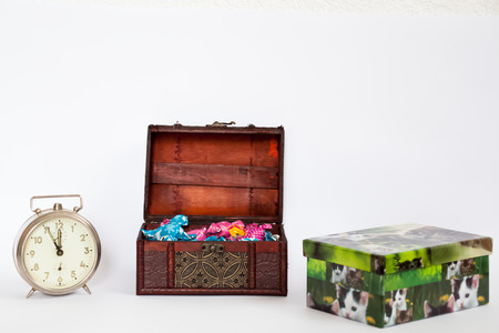 Tresure box full of colorful bonbons with a clock showing the last five minutes and a present box with pictures of catsの写真素材