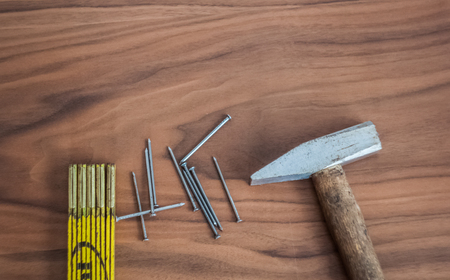 Hammer, nails and meter stick on a wooden table deskの写真素材