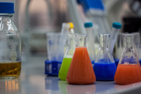 biotechnological laboratory equipment for research. Flasks, bottles and pipettes with colorful...