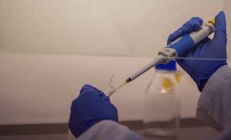 Modern scientist working in biotechnological laboratory equipment for research with test tube...