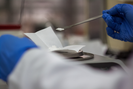 Scientist phd student taking from balance scale DNA samples from litmus paper to check ph value in biotechnology laboratoryの写真素材